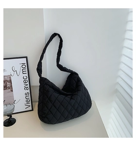 Detail view of the black quilted tote bag showing a soft padded texture and stitching