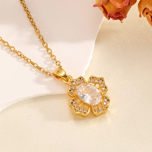 Vue détaillée d'un collier pendentif fleur dorée avec cristal ovale sur tissu de soie
