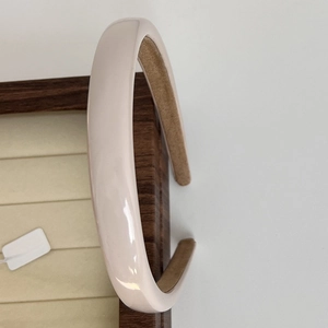 Detailed view of the beige glossy headband with a brown frosted non-slip inner lining