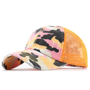 Detailed view of the distressed pink camouflage trucker hat with orange mesh and frayed edges