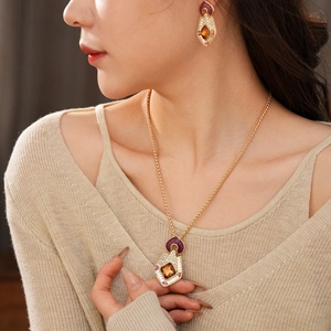 Detail view of vintage diamond gold necklace and earring set with amber red gems