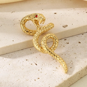 Macro shot of gold snake pendant with detailed scales and ruby red gemstone eyes