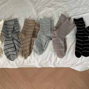 Flat lay of five pairs of Morandi-colored ribbed socks in grey, blue, and purple tones