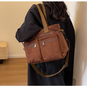 Detailed view of the brown corduroy shoulder bag with multiple functional zippers