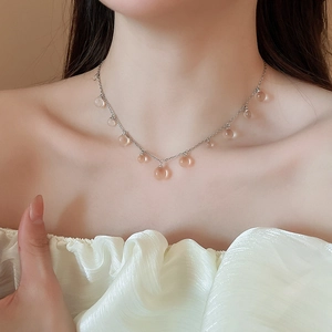 Détail d'un collier en acier inoxydable avec perles en résine porté par un mannequin
