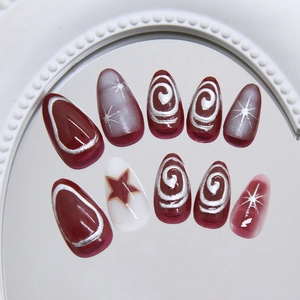 Deep red and white almond press on nails with silver spiral lines and star patterns