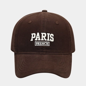 Macro detail of PARIS FRENCH white embroidery on brown cotton canvas baseball cap