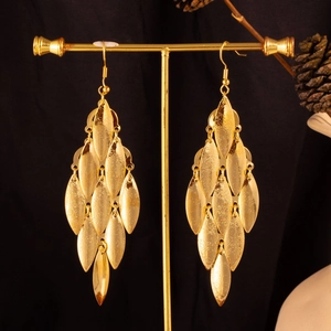 Detail of gold layered leaf tassel earrings on a display stand with a macro focus