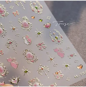 Détail macro des stickers ongles M-780 avec motifs chat rose, nœud et étoiles dorées