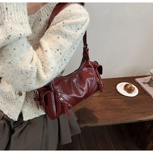 Deep red vintage leather shoulder bag with multiple zippers shown on a model side view