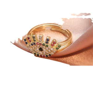 Adjustable gold evil eye ring featuring vibrant colorful zircon stones on pink silk cloth