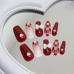 Short ballet press-on nails with red checkerboard pattern and 3D white bow designs