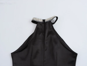 Detail of elegant black satin halter neck dress featuring intricate beaded rhinestone collar