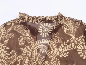 Detail van de halslijn van een boheemse chiffon jurk met paisleyprint en ruches