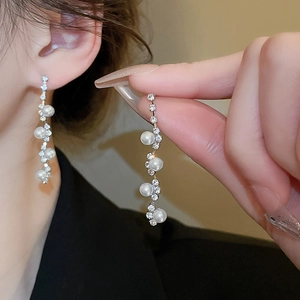 Elegant jewelry set featuring long drop earrings with imitation pearls and sparkling rhinestones
