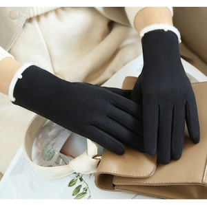 Detail von schwarzen Wildlederhandschuhen mit weißem Pelzbesatz und Perlenverzierung