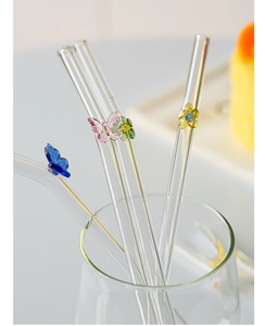 Close-up of heat-resistant glass straws with colorful butterfly and flower decorations