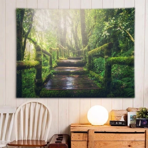 Detail of forest tapestry hanging over a wooden cabinet in a cozy bedroom setting