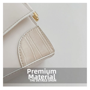 Detail of white crossbody bag featuring smooth leather stitched with crocodile texture