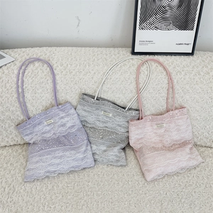 Detailed view of large lace tote bags with shimmering sequins in purple, gray, and pink