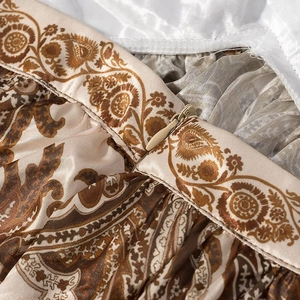 Dettaglio in raso marrone con motivo paisley e cerniera invisibile sulla vita del vestito