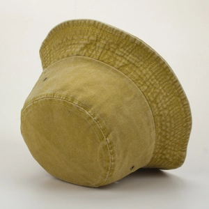 Détail d'un chapeau bob en coton délavé jaune moutarde avec coutures et œillets