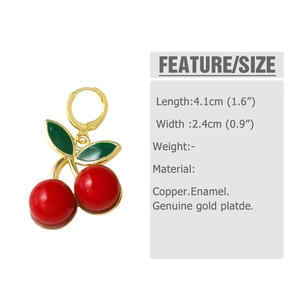 Detail of red enamel cherry earrings with gold plated copper and green leaf accents