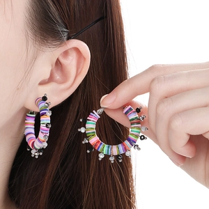 Gros plan détaillé de boucles d'oreilles créoles en perles Heishi aux couleurs vives
