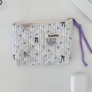 Detailed top view of quilted floral makeup bag with blue stripes and purple zipper cord