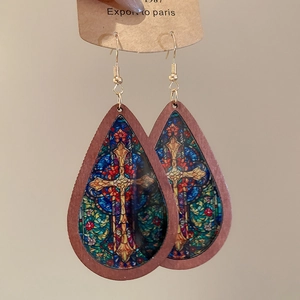 Detailed view of teardrop wood earrings with colorful vintage religious cross patterns