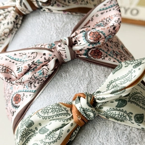 Macro view of paisley print fabric headbands featuring stylish knotted bow details