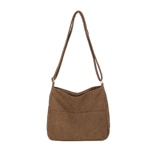 Minimalist brown corduroy bucket bag with adjustable shoulder strap on white background