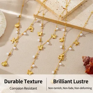 Detailed close-up of matte gold Y-necklace with starfish charms and pearls on stone