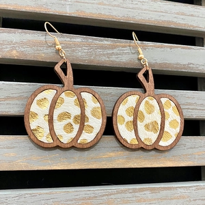 Detalle de pendientes de cuero con forma de calabaza y estampado de leopardo y madera