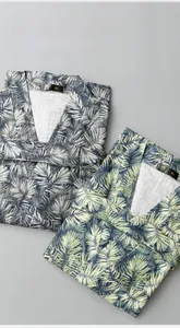 Detail of waffle texture and tropical palm leaf prints on folded soft cotton bathrobes