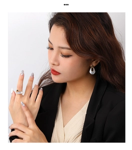 Model wearing gold geometric jewelry set with white mother of pearl inlay detail