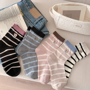 Détail de quatre paires de chaussettes rayées avec broderie d'ours et petits nœuds bleus