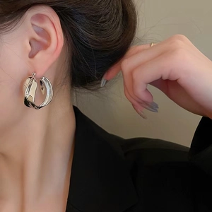 Minimalist twisted geometric silver earrings shown on model for high fashion style