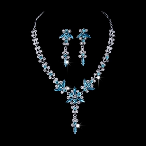Detailed view of bridal crystal necklace and blue rhinestone earrings set on black background