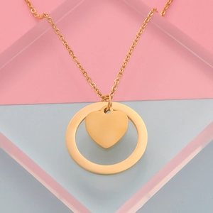 Detail van gouden roestvrijstalen ketting met cirkel en hart hanger op gekleurde blokken