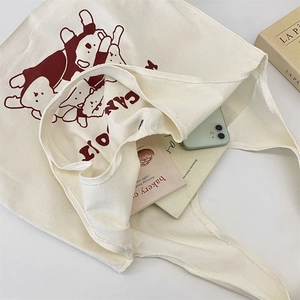 Détail de l'intérieur spacieux du sac en toile contenant des livres et un smartphone