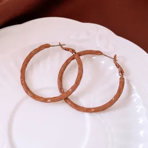 Minimalist caramel brown hoop earrings with hammered matte finish and silver needle posts