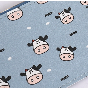 Detail of light blue cow print wallet showing fine stitching and smooth leather texture