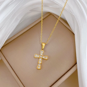 Detailed macro shot of a gold titanium steel cross necklace with sparkling crystals