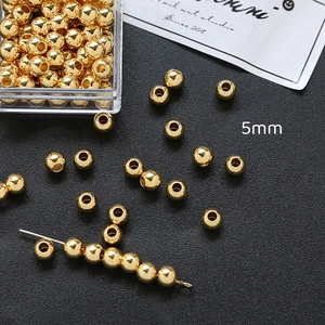 Vista macro de cuentas espaciadoras de cobre doradas de 5mm para hacer joyas