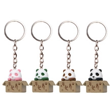 Close-up of four colorful cartoon panda keychains popping out of boxes for bag charms