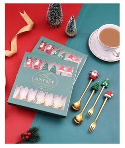 Detail of Christmas cutlery set with Santa and tree resin ornaments in gift boxes