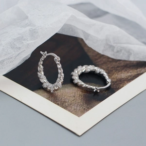 Macro detail of S925 silver twisted hoop earrings with sparkling zircon stones