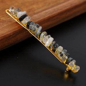 Macro shot of handmade gold wire hair clip with black natural crystal stone chips