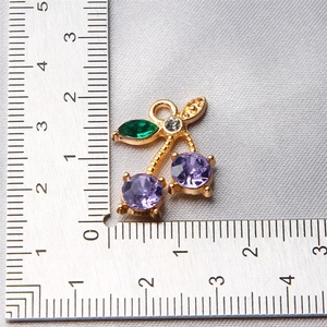 Detail of cherry fruit pendant with purple gems and ruler showing 2.5cm size